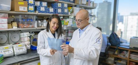 (Dr. Salima Benbarche (left) and Dr. Omar Abdel-Wahab (right) look at something in their lab at Memorial Sloan Kettering Cancer Center in New York City.