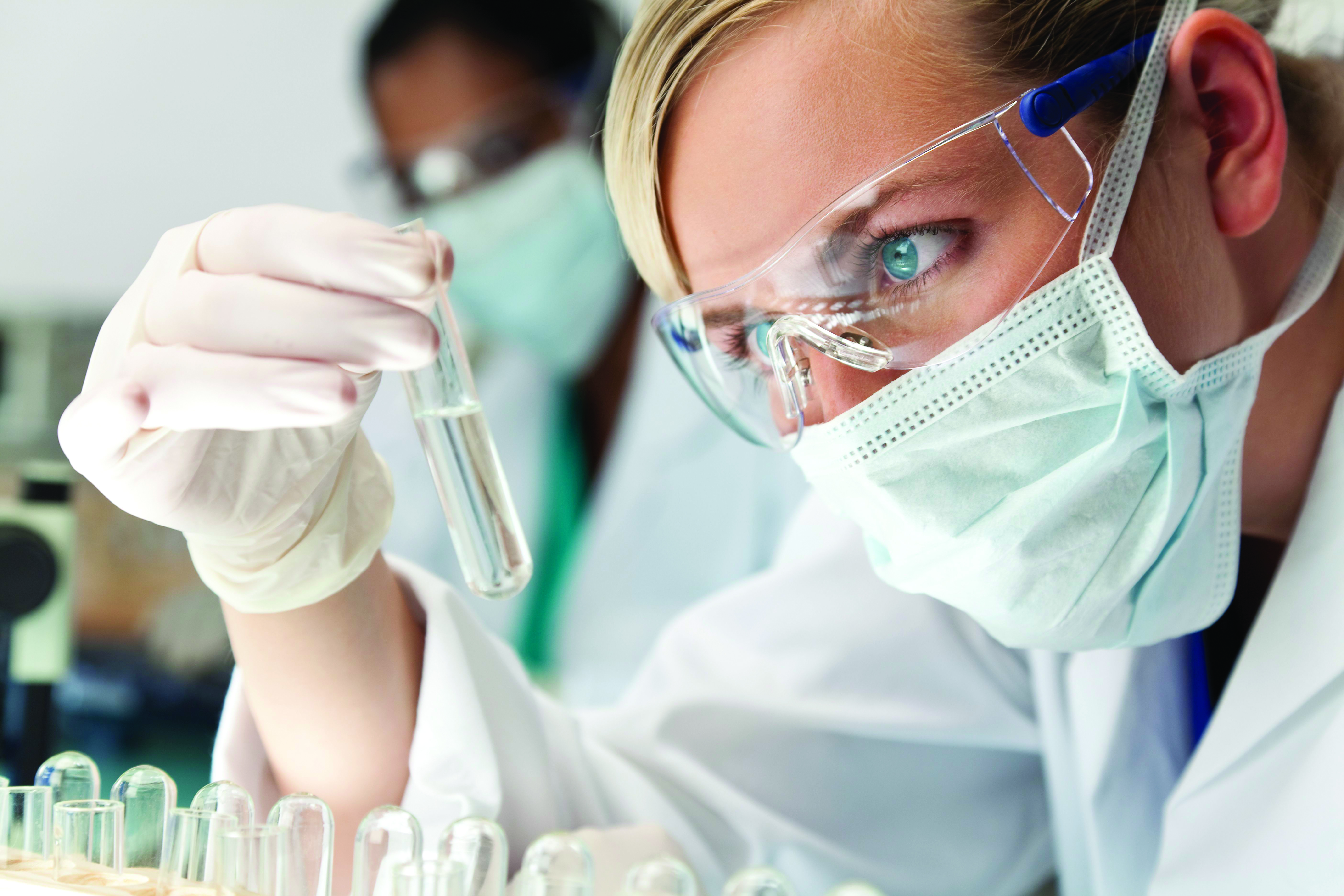 A researcher analyzes a specimen in a test tube.