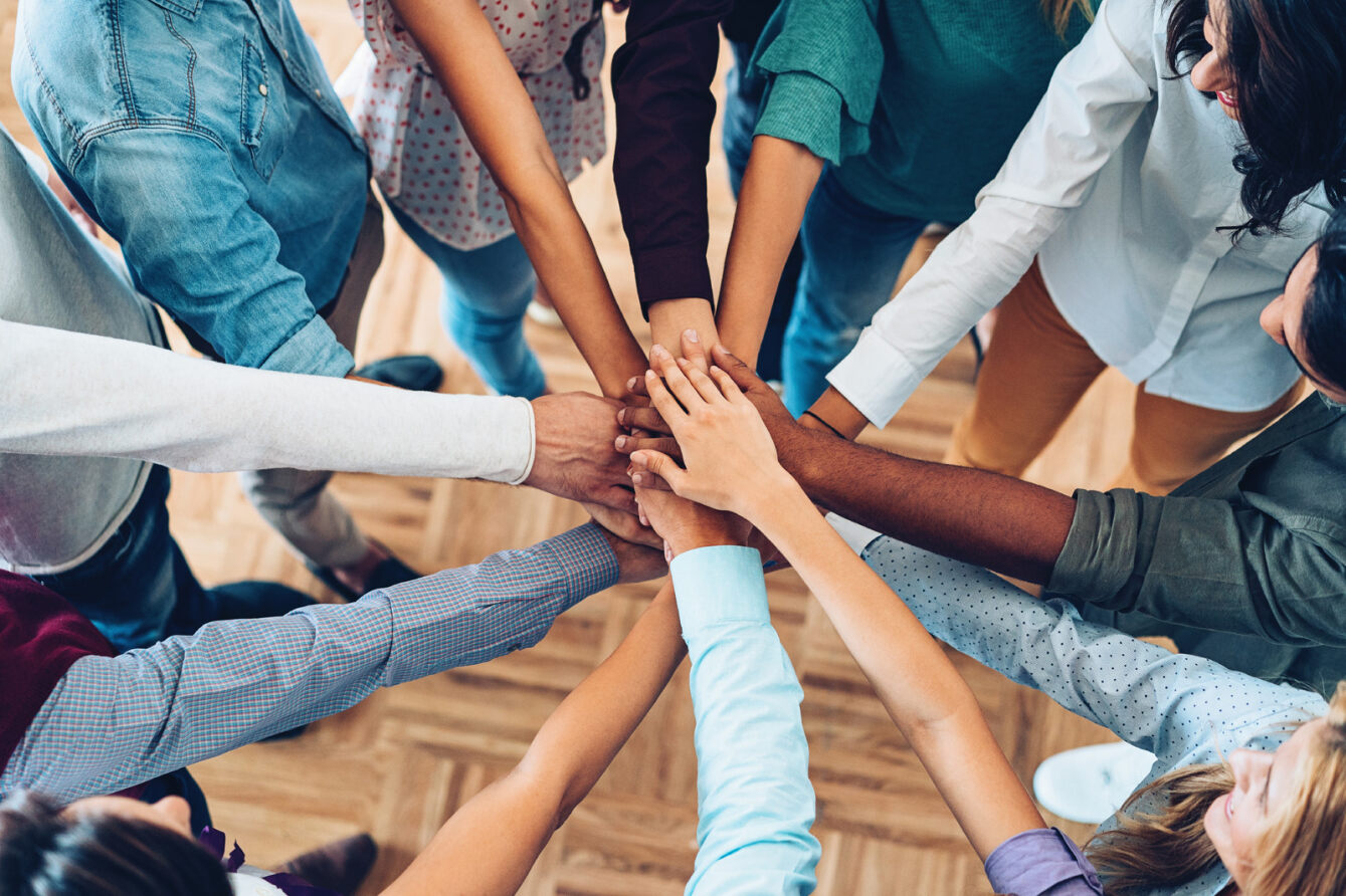 Group of people putting hands in center