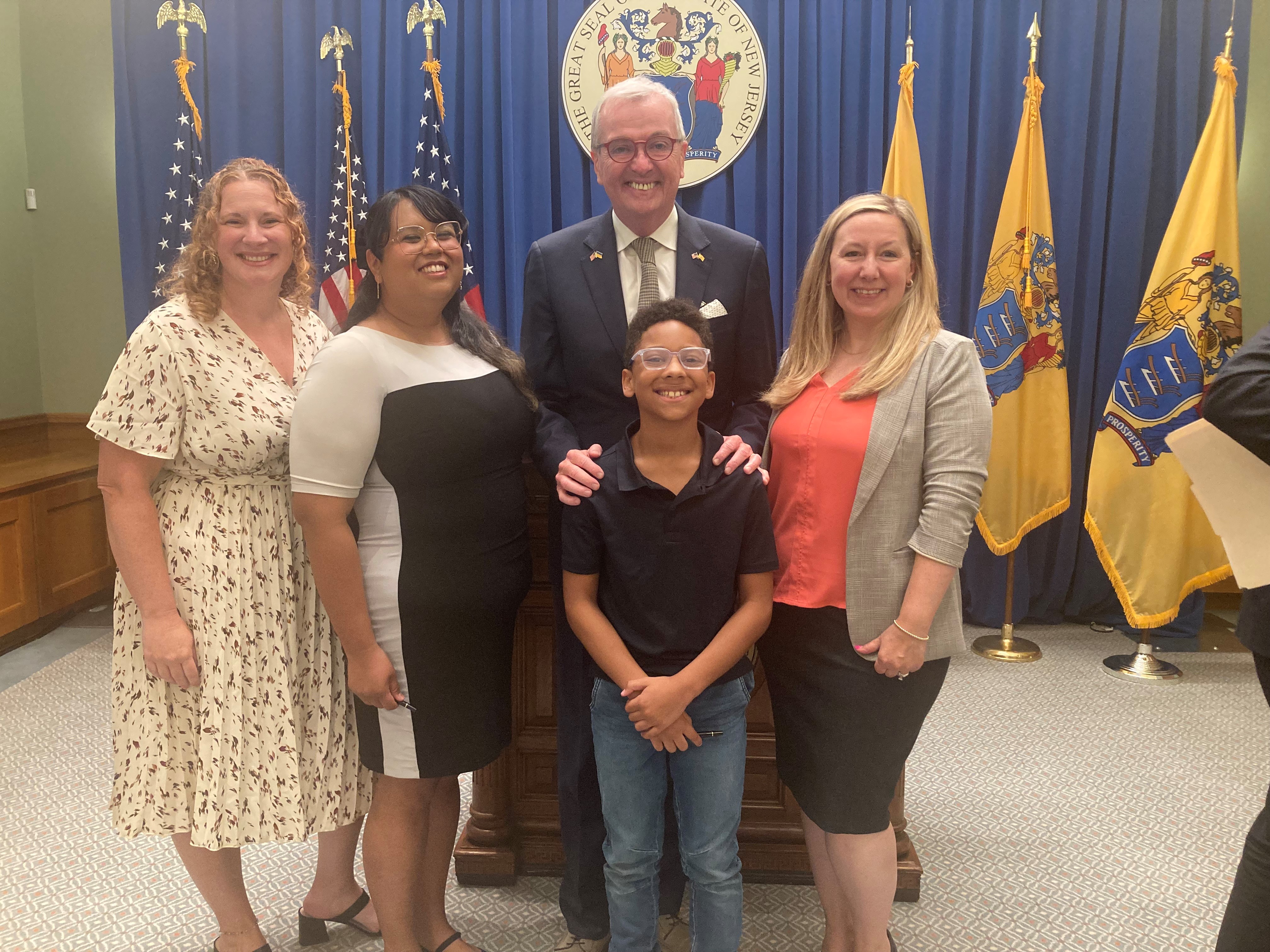 Advocates standing alongside NJ governor for the medical debt bill signing ceremony