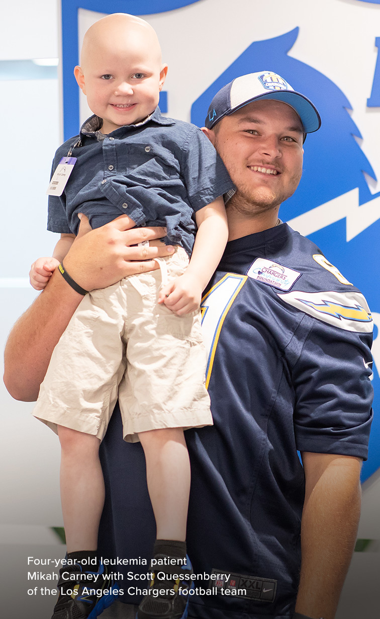 Four-year-old ALL patient Mikah Carney with Scott Quessenberry of the Los Angeles Chargers football team