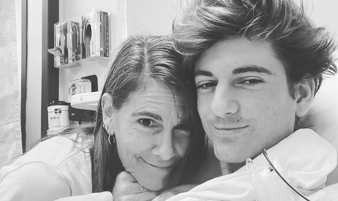 Michael and Ashlee black and white photo of Mom with three earrings in right ear and teenage son with stylish hair in a hospital room
