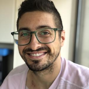 Young man with glasses and a pink shirt