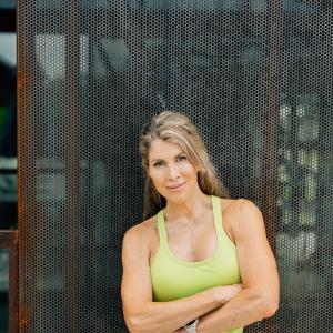 extremely fit middle aged white woman in lime green tank and shorts