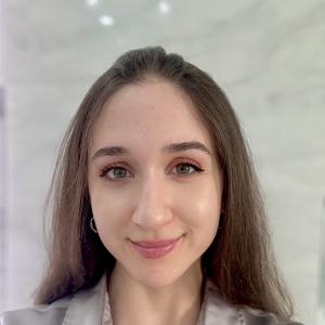 young hispanic woman with large green eyes an pink lipstick wearing a grayish blouse