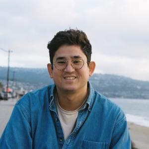 leukemia patient weaing glasses and blue shirt at the beach