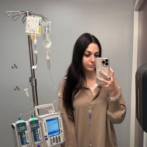 young adult patient lymphoma standing with IV pole in front of a mirror selfie