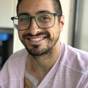 Young man with glasses and a pink shirt