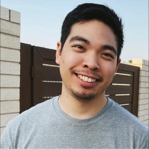 young adult smiling with short dark hair blood cancer survivor
