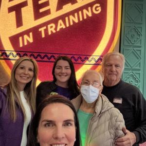 Alexis family of five with grandmother wearing glasses and a mask standing in front of TNT photo