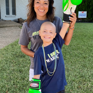 Peyton young hispanic mom in a gray tshirt with her bald son wearing bright green boxing gloves and an I Am a Warrior tshirt