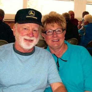 myeloma patient older white man with white beard and mustache wearing John Deere hat and blue tshirt with wife with short hair glasses and turquoise shirt