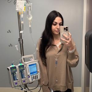 young adult patient lymphoma standing with IV pole in front of a mirror selfie
