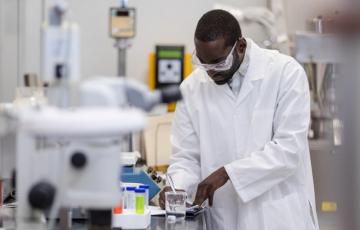 scientist in research lab, taking notes