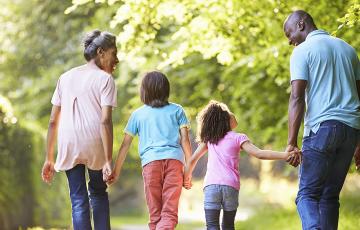 Family holding hands walking away from camera