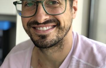 Young man with glasses and a pink shirt