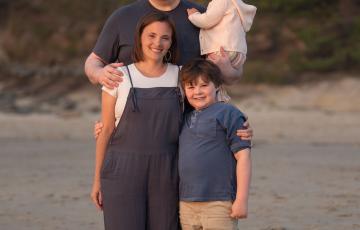 family impacted by blood cancer leukemia standing on the beach