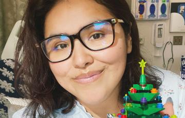 leukemia patient holding a christmas tree lego at the hospital during treatment