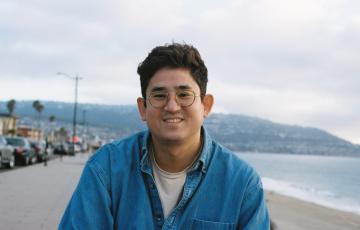 leukemia patient weaing glasses and blue shirt at the beach