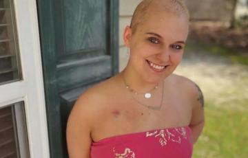 young adult blood cancer survivor with a pink wrap dress and port scar smiling nodular sclerosis Hodgkin lymphoma (NSHL)