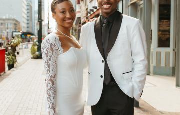 Jayson young black couple in wedding attire white coat black shirt and tie standing outside in a downtown area